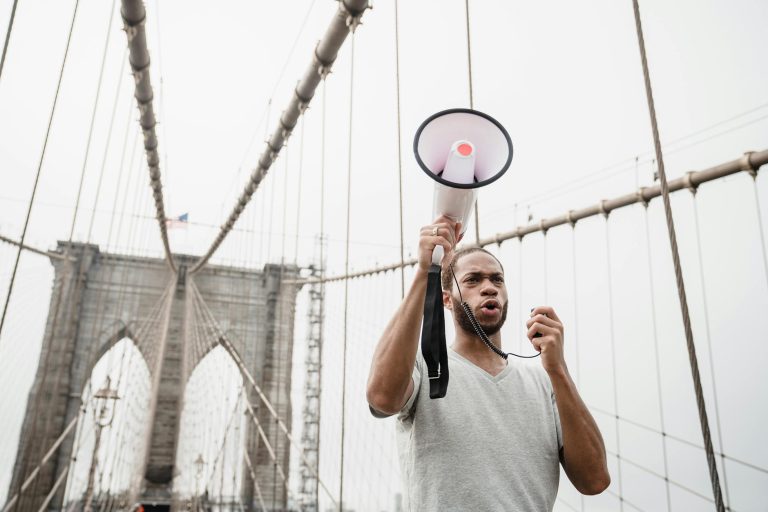 man with megaphone on protest on bridge