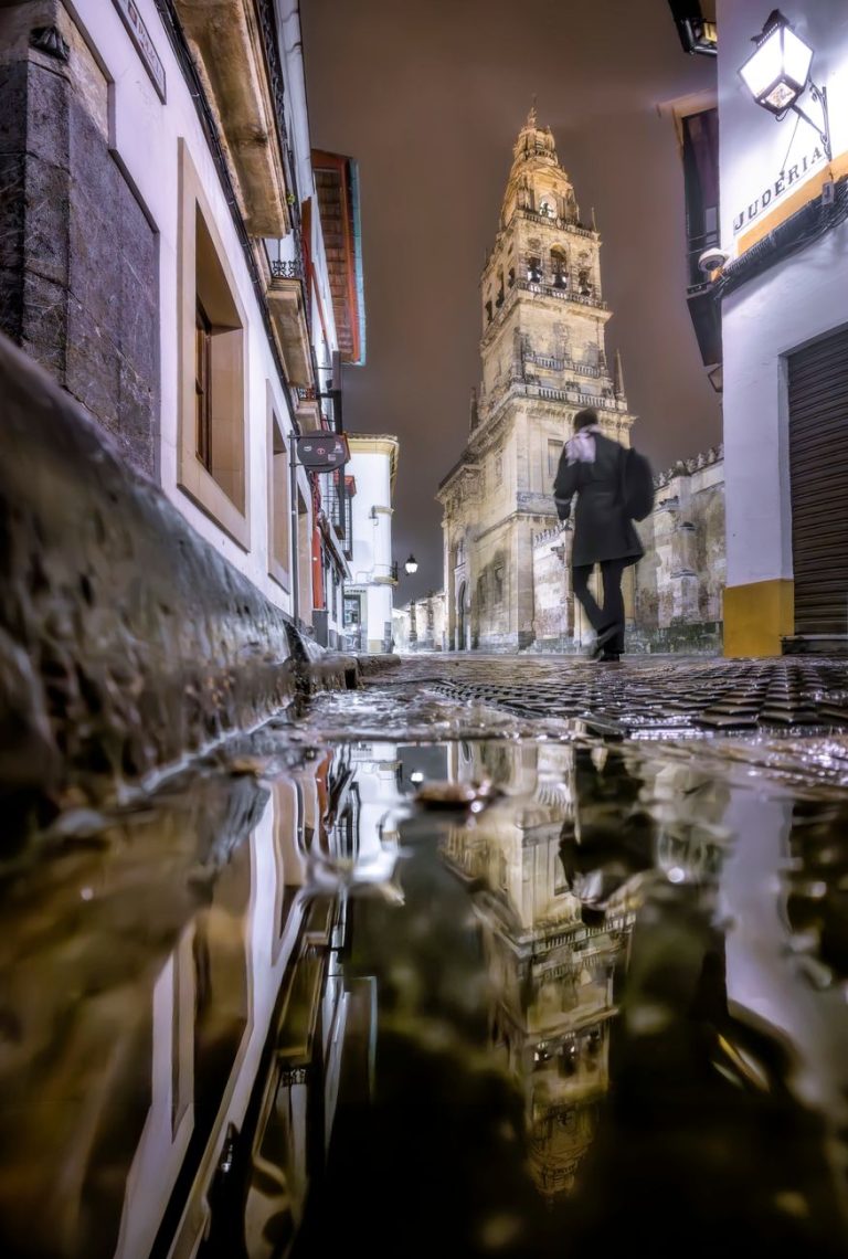 puddle of water in an illuminated alley at night